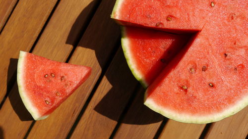 Directly above shot of watermelon and slice on wooden table
