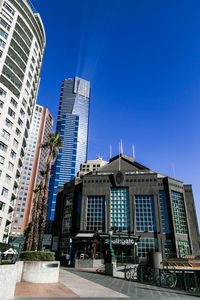 Low angle view of buildings against clear blue sky