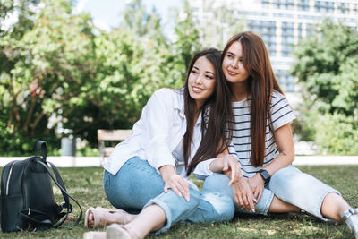 Young beautiful asian girls with long hair in casual clothes, friends having fun in city park