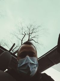 Portrait of man in car against sky