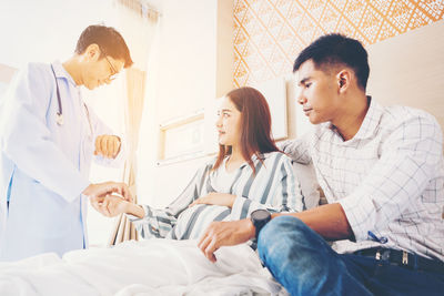 Young couple standing on bed