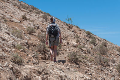 Rear view of man walking on mountain
