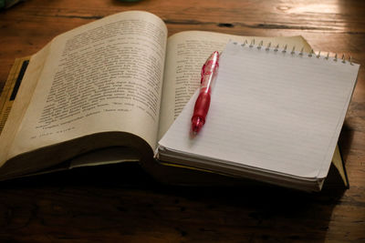 High angle view of books and pen on table