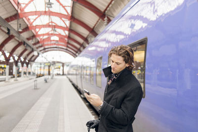 Man using phone at train station