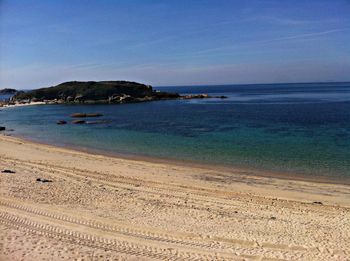 Scenic view of beach against blue sky