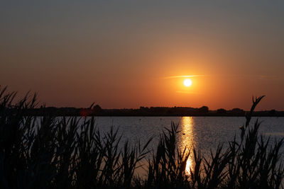 Scenic view of lake against romantic sky at sunset