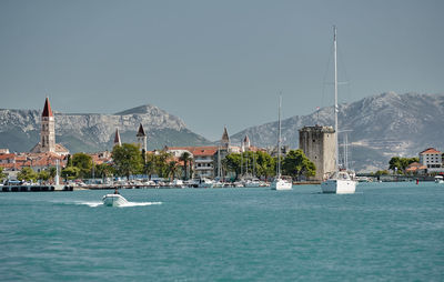 Sailboats in sea against sky