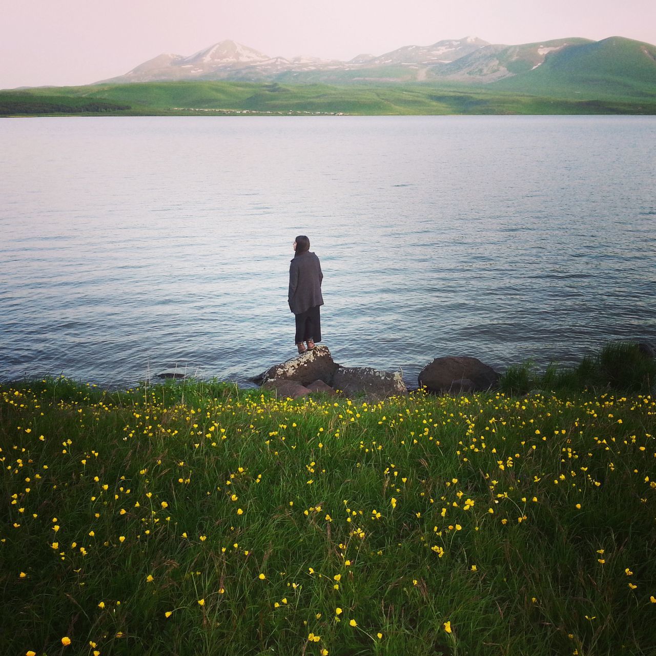 water, rear view, tranquil scene, lifestyles, tranquility, beauty in nature, leisure activity, standing, nature, lake, scenics, full length, casual clothing, person, men, getting away from it all, grass, plant