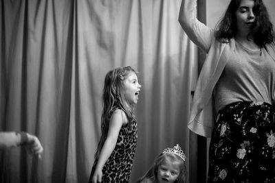 Mother with happy daughters dancing at home