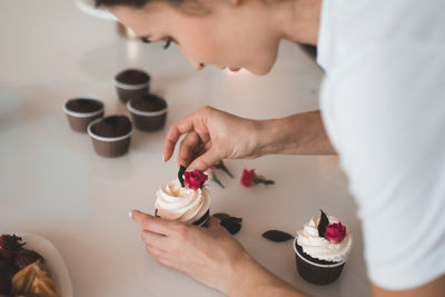 High angle view of woman holding coffee on table