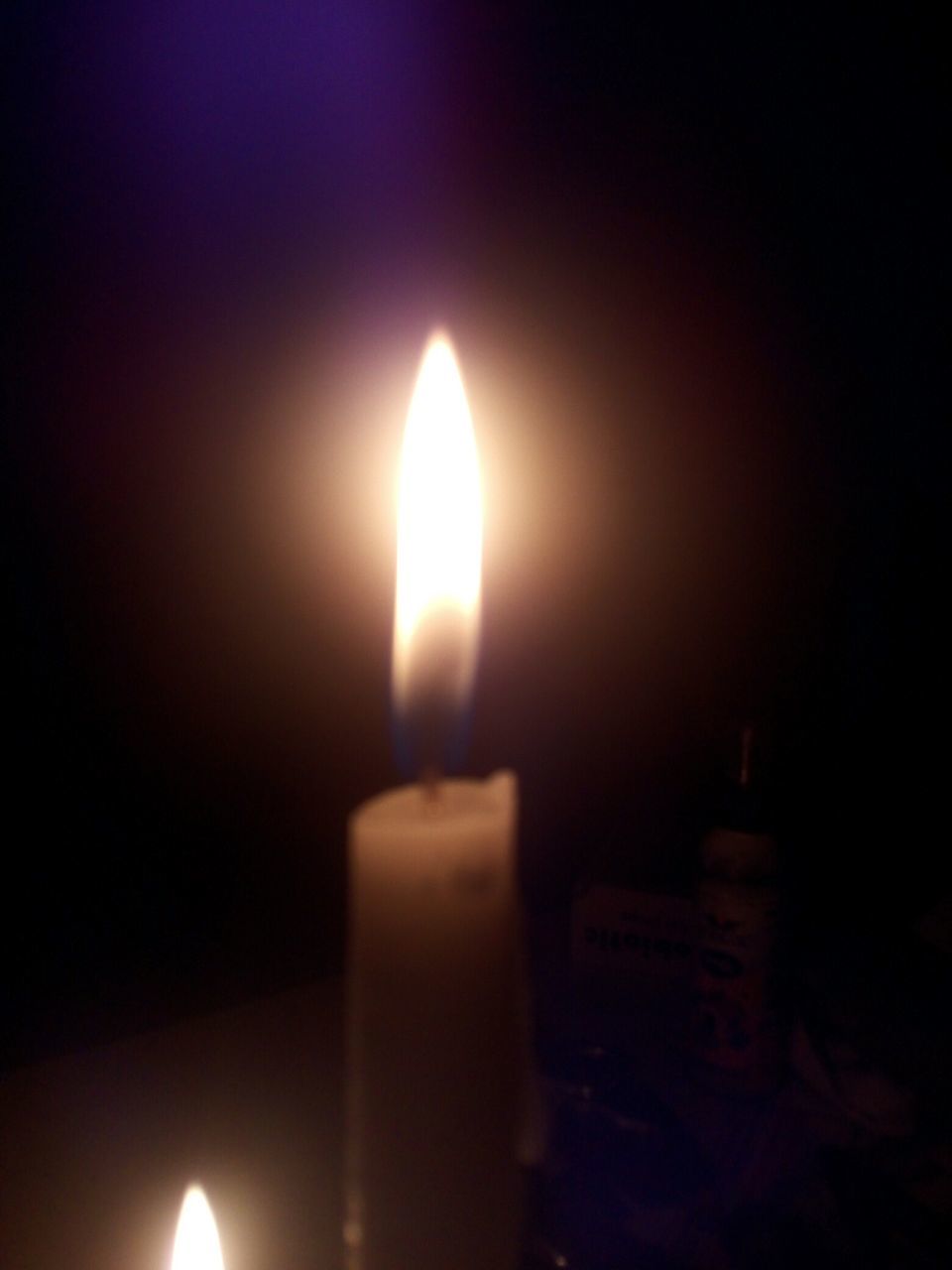 CLOSE-UP OF LIT CANDLES IN THE DARK