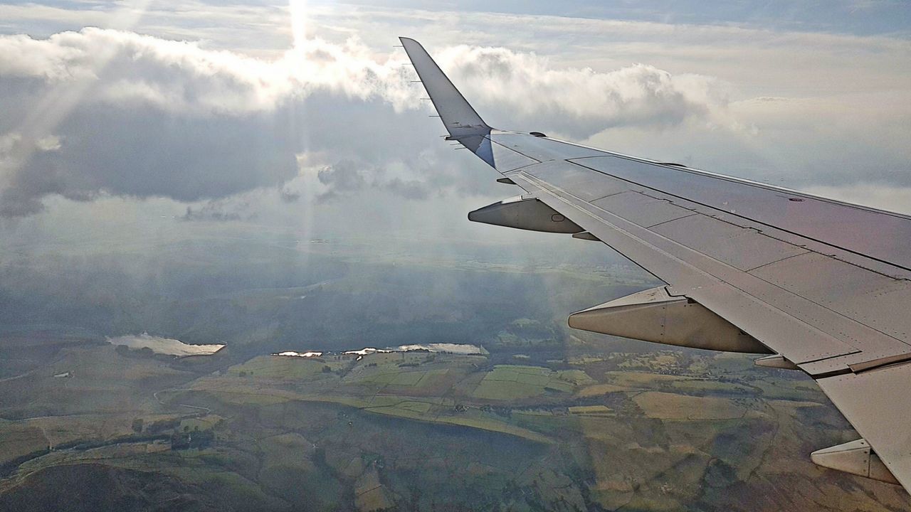 AERIAL VIEW OF AIRCRAFT WING AGAINST SKY