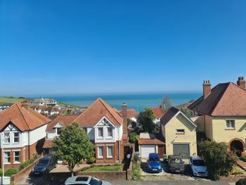 Houses and buildings against clear blue sky