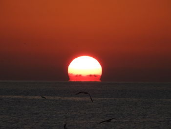 Scenic view of sea against orange sky