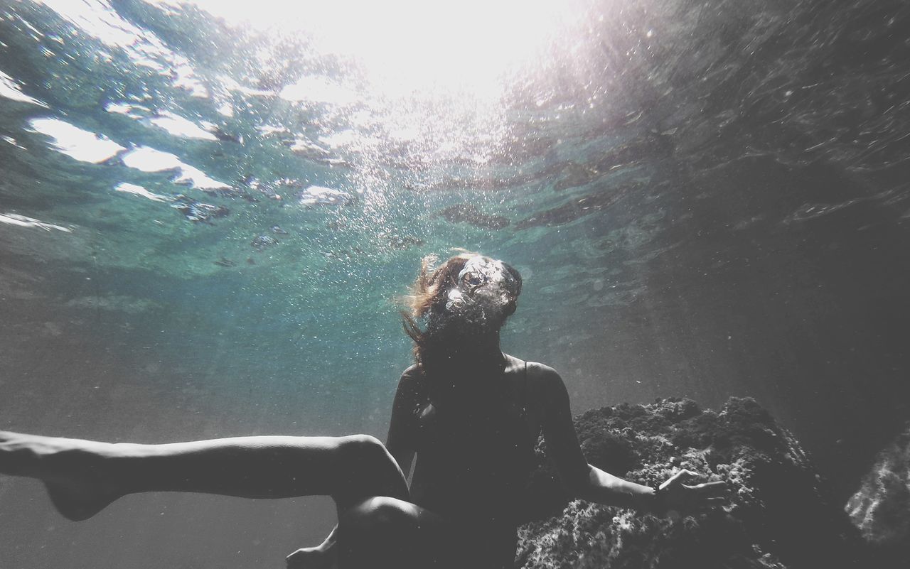 REAR VIEW OF SHIRTLESS MAN IN SEA