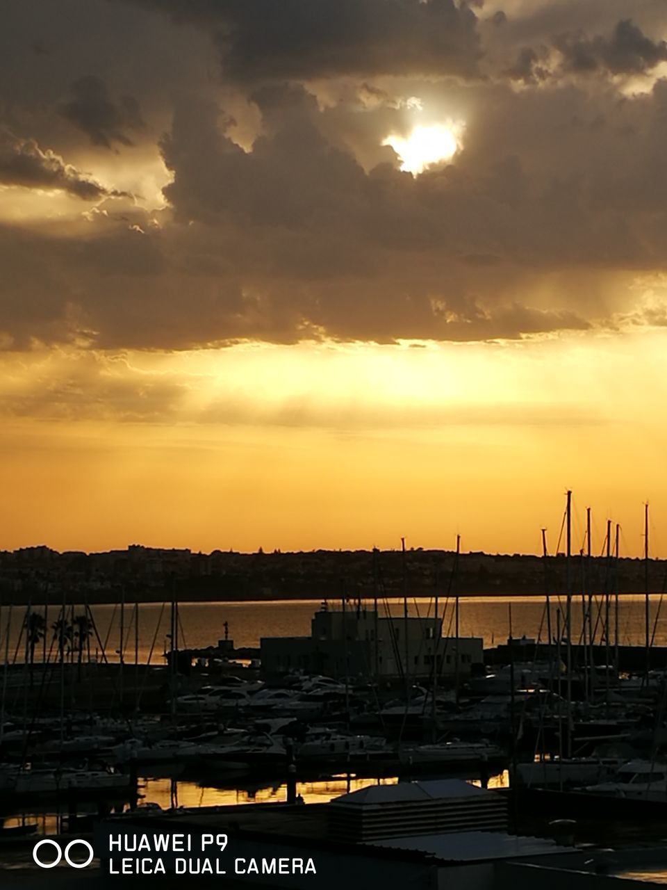 sunset, transportation, cloud - sky, sky, nautical vessel, city, mode of transport, harbor, cloud, water, orange color, sea, scenics, commercial dock, sun, outdoors, cloudy, ocean, large group of objects, development, cloudscape, no people, shipping, tranquil scene, city life