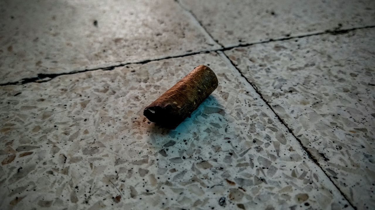 HIGH ANGLE VIEW OF CIGARETTE ON WOOD