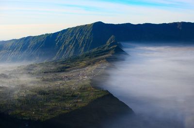 Scenic view of land and mountains against sky