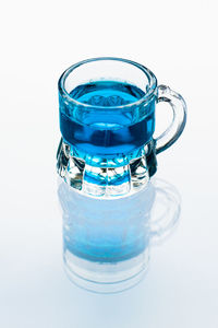 Close-up of blue glass against white background