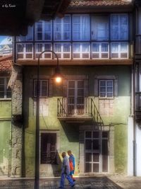 Rear view of woman standing in front of building