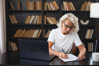 Man using laptop while sitting on table