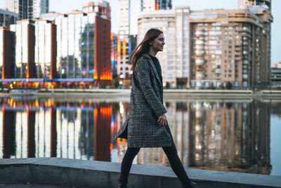 Portrait of young woman standing in city