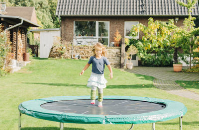 Full length of girl playing on trampoline