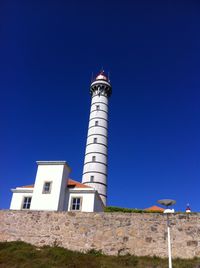 Low angle view of lighthouse against clear blue sky