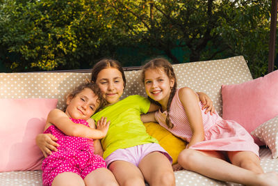 Portrait of smiling girl sitting outdoors