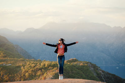 Portrait of woman standing on mountain against sky