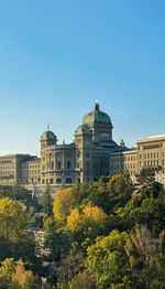 Low angle view of buildings against clear blue sky