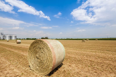 Hay bales on field against sky