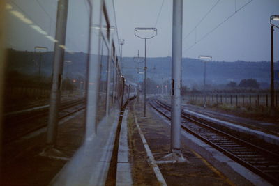 Railroad tracks against sky seen through train windshield