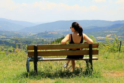 Man sitting on bench in field