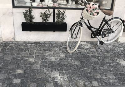 Bicycle on footpath against wall