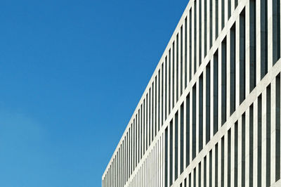 Low angle view of modern building against clear blue sky