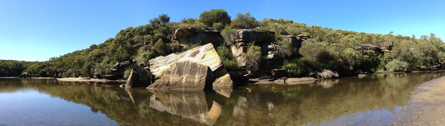 Panoramic view of lake against clear blue sky