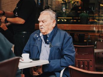 Man and coffee cup on table at restaurant