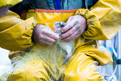 Close-up of man holding yellow water