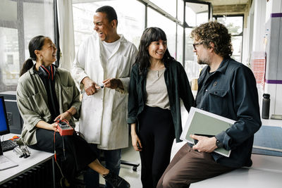 Happy male and female entrepreneurs having fun while talking with each other at repair shop