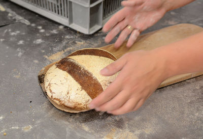 Close-up of hand holding bread at counter in kitchen