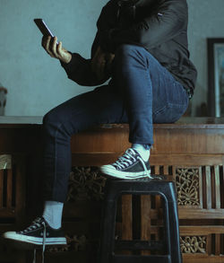 Low section of man sitting on chair at home