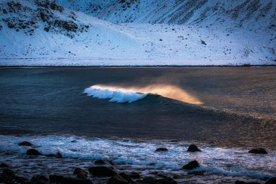 Scenic view of waves rushing towards shore against sky