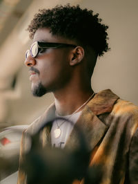 Young man looking away against wall