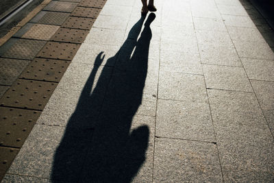 Shadow of people walking on footpath