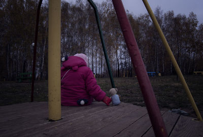 Rear view of woman sitting on bench
