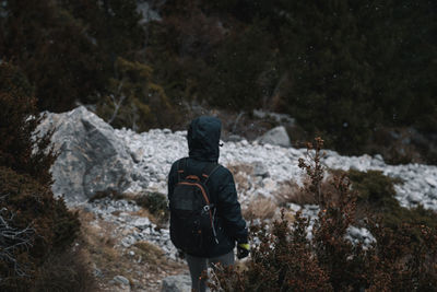 Rear view of man standing on snow covered land