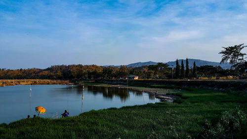 Scenic view of lake against cloudy sky