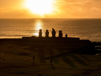 Silhouette people on beach during sunset