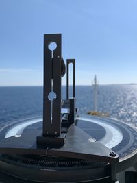 Close-up of telephone on table against sea